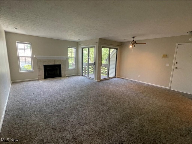1304 Cedarwood Dr Unit D2, Westlake, OH 44145 - unfurnished living room with carpet flooring, a ceiling fan, a tiled fireplace, and a textured ceiling