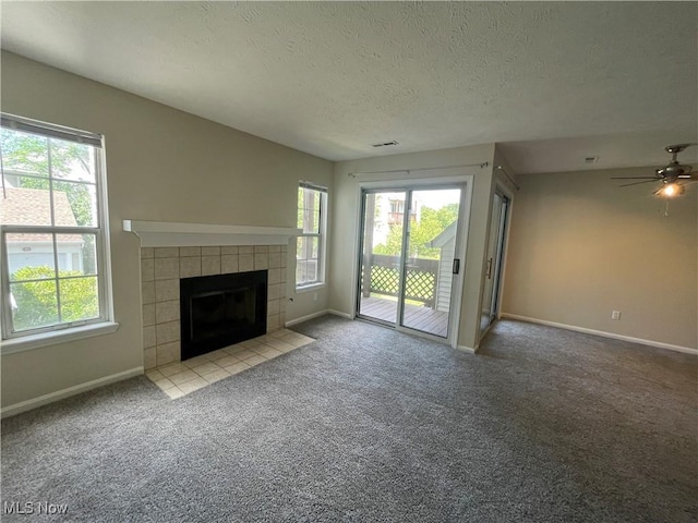 1304 Cedarwood Dr Unit D2, Westlake, OH 44145 - unfurnished living room featuring healthy amount of natural light, carpet floors, a tile fireplace, and a textured ceiling