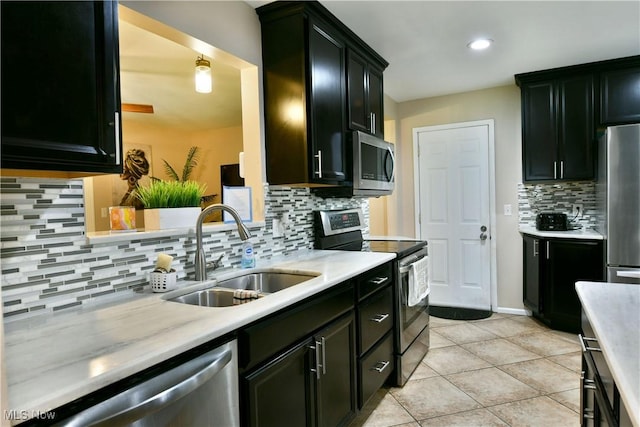 3992 Allenwood Dr SE, Warren, OH 44484 - kitchen with stainless steel appliances, tasteful backsplash, light countertops, light tile patterned floors, and dark cabinetry
