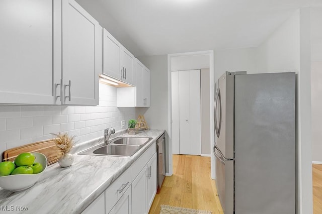 25801 Lake Shore Blvd Unit 28, Euclid, OH 44132 - kitchen with appliances with stainless steel finishes, light wood-style floors, tasteful backsplash, light countertops, and white cabinets