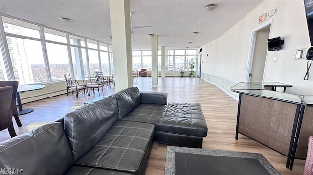 25801 Lake Shore Blvd Unit 28, Euclid, OH 44132 - living area with wood finished floors, healthy amount of natural light, a textured ceiling, and a baseboard heating unit