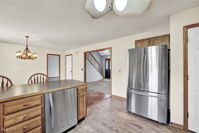 1550 Rebel St SW, Canton, OH 44706 - kitchen featuring freestanding refrigerator, refrigerator, a chandelier, brown cabinets, and decorative light fixtures