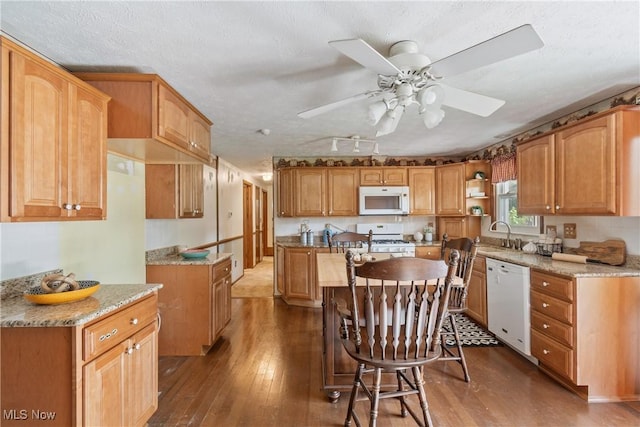 578 25th St NW, Massillon, OH 44647 - kitchen with white appliances, wood-type flooring, a ceiling fan, a kitchen island, and a textured ceiling