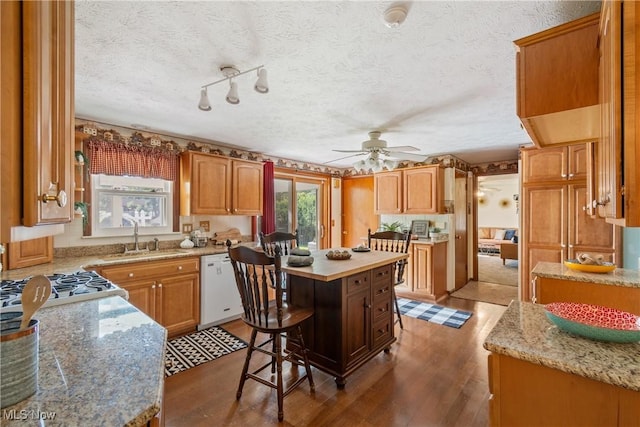 578 25th St NW, Massillon, OH 44647 - kitchen featuring white dishwasher, wood finished floors, a kitchen island, ceiling fan, and a textured ceiling
