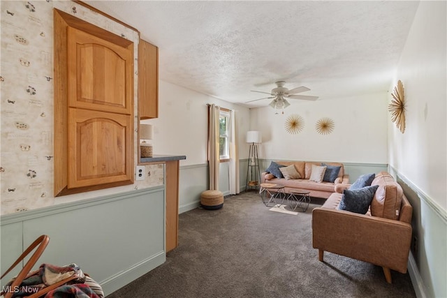 578 25th St NW, Massillon, OH 44647 - living area with a ceiling fan, dark colored carpet, a textured ceiling, and wainscoting