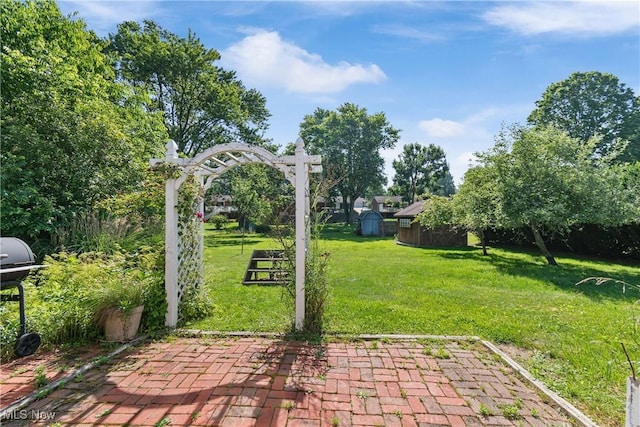 578 25th St NW, Massillon, OH 44647 - view of green lawn featuring a storage shed and a patio area