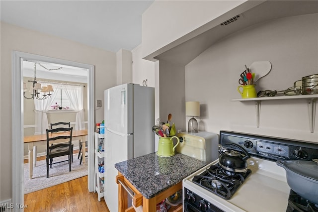 5100 Edenhurst Rd, Lyndhurst, OH 44124 - kitchen featuring range with electric stovetop, freestanding refrigerator, a chandelier, and light wood finished floors