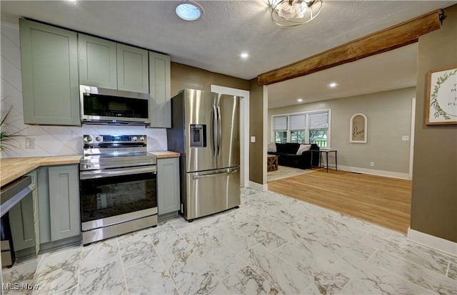 8171 Pheasant Ave NW, North Canton, OH 44720 - kitchen with appliances with stainless steel finishes, butcher block counters, recessed lighting, beam ceiling, and decorative backsplash
