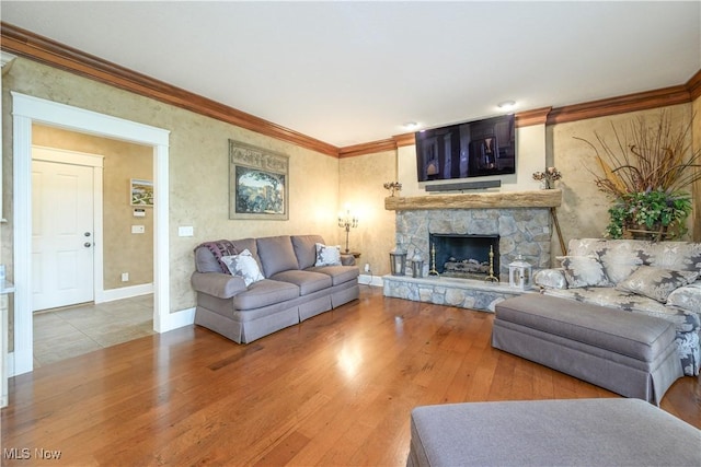 8309 Gentry St NW, Massillon, OH 44646 - living area featuring wood finished floors, a stone fireplace, and crown molding