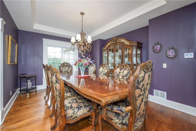 8309 Gentry St NW, Massillon, OH 44646 - dining room featuring a tray ceiling, a chandelier, wood finished floors, and crown molding