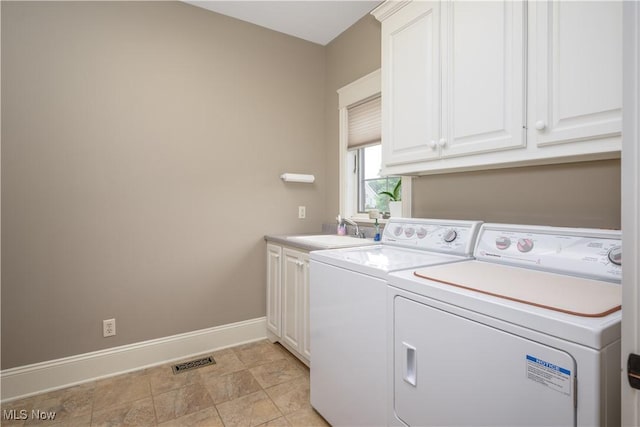 8309 Gentry St NW, Massillon, OH 44646 - laundry area featuring cabinet space, washing machine and clothes dryer, and stone finish flooring