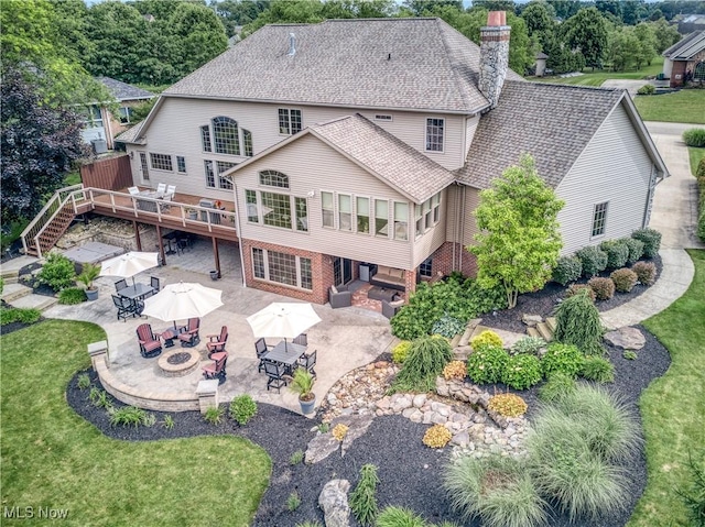 8309 Gentry St NW, Massillon, OH 44646 - back of property featuring a fire pit, a patio, a deck, and outdoor dining area