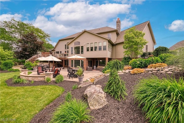 8309 Gentry St NW, Massillon, OH 44646 - back of house featuring a patio, a chimney, and a lawn
