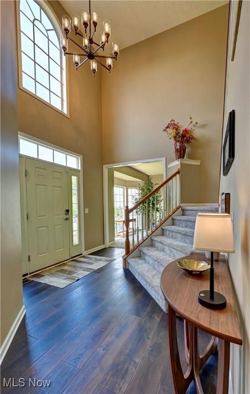 2720 Pinegate Dr, Norton, OH 44203 - entryway with a chandelier, stairs, dark wood-style flooring, and a high ceiling