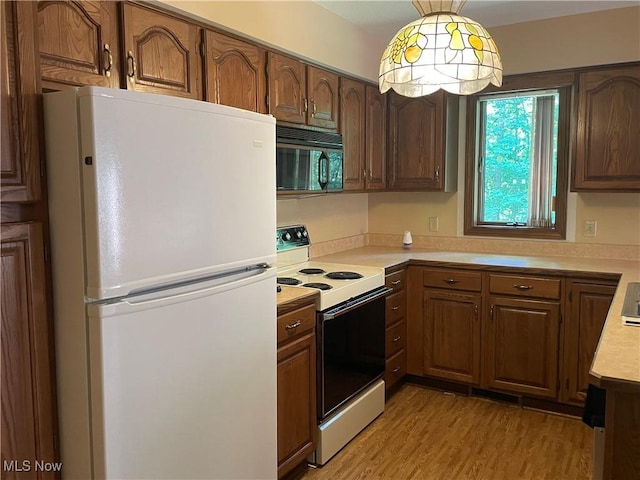 5450 King Graves Rd, Vienna, OH 44473 - kitchen with white appliances, light countertops, light wood finished floors, pendant lighting, and brown cabinets