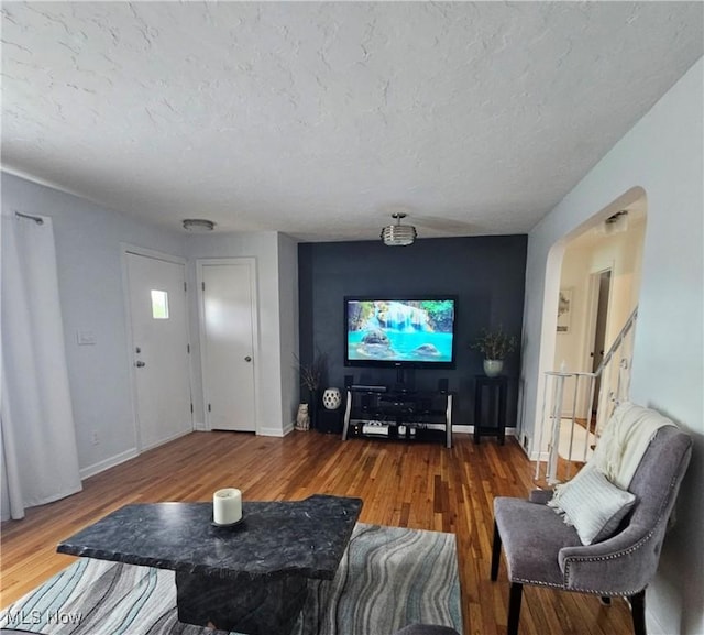 5711 W 54th St, Parma, OH 44129 - living room featuring arched walkways, wood finished floors, and a textured ceiling