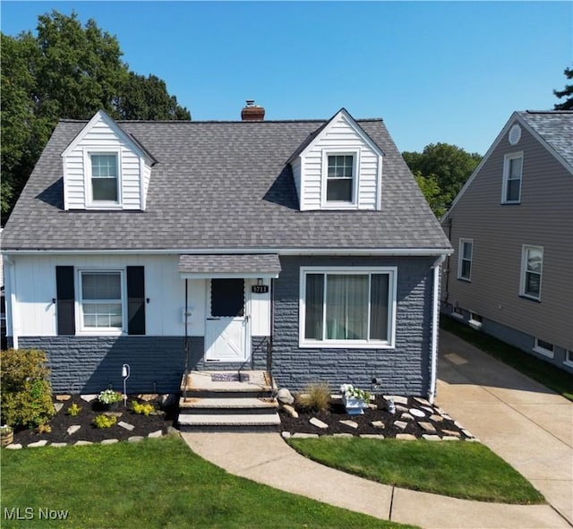 5711 W 54th St, Parma, OH 44129 - cape cod-style house with a chimney, roof with shingles, and board and batten siding