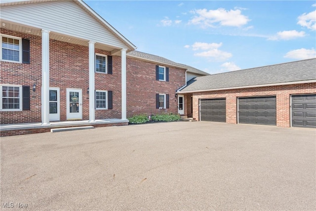 1234 W Maple St, North Canton, OH 44720 - view of side of home featuring brick siding, driveway, and a garage