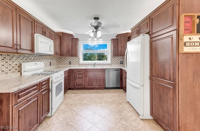 201 Noble St W, East Canton, OH 44730 - kitchen with white appliances, decorative backsplash, light countertops, and brown cabinets