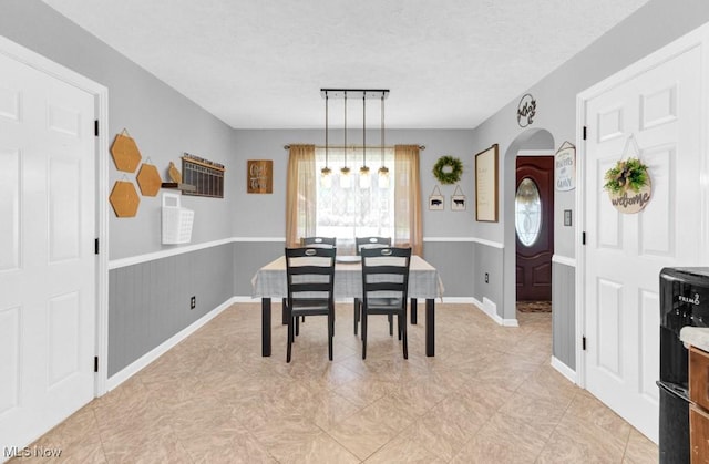 201 Noble St W, East Canton, OH 44730 - dining area featuring arched walkways, wainscoting, and a textured ceiling