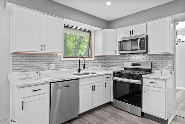 1303 E Dartmoor Ave, Seven Hills, OH 44131 - kitchen featuring stainless steel appliances, light wood-type flooring, white cabinetry, backsplash, and light stone counters