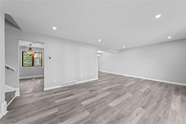 1303 E Dartmoor Ave, Seven Hills, OH 44131 - unfurnished room featuring recessed lighting, wood finished floors, a chandelier, and stairway