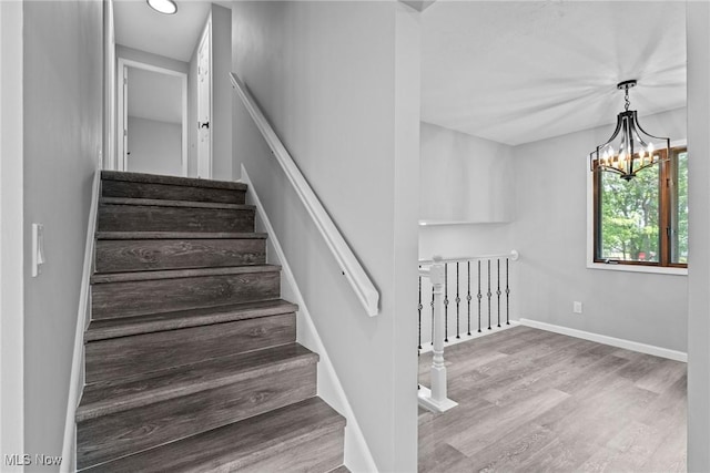 1303 E Dartmoor Ave, Seven Hills, OH 44131 - stairway with wood finished floors and a chandelier