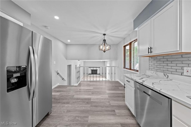 1303 E Dartmoor Ave, Seven Hills, OH 44131 - kitchen featuring appliances with stainless steel finishes, white cabinets, light stone counters, recessed lighting, and decorative backsplash