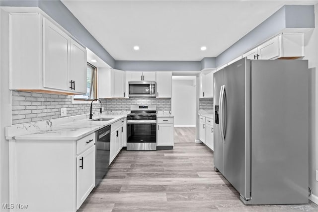 1303 E Dartmoor Ave, Seven Hills, OH 44131 - kitchen featuring stainless steel appliances, white cabinets, light stone countertops, and recessed lighting