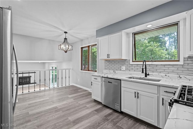 1303 E Dartmoor Ave, Seven Hills, OH 44131 - kitchen featuring appliances with stainless steel finishes, decorative backsplash, light stone countertops, and white cabinets