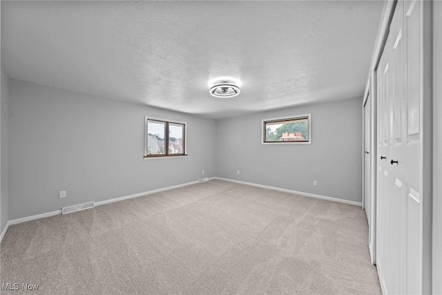 1303 E Dartmoor Ave, Seven Hills, OH 44131 - unfurnished bedroom with a textured ceiling, light carpet, and a closet
