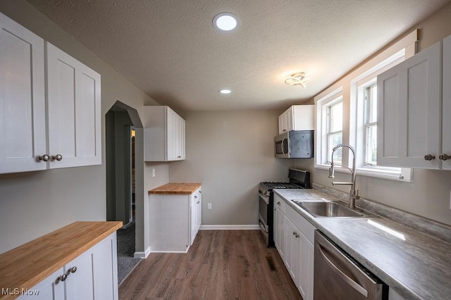 1320 21st St, Vienna, WV 26105 - kitchen with stainless steel appliances, wood counters, dark wood-style flooring, white cabinets, and a textured ceiling