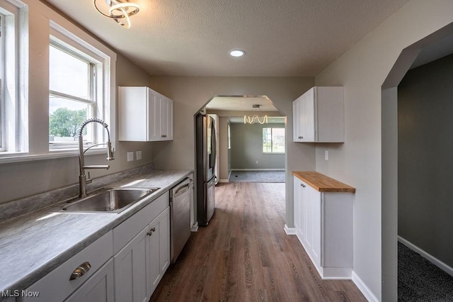 1320 21st St, Vienna, WV 26105 - kitchen with stainless steel appliances, a textured ceiling, white cabinets, healthy amount of natural light, and dark wood-style flooring