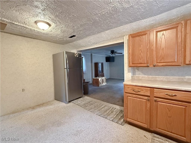 8756 Cook Rd, Salem, OH 44460 - kitchen featuring freestanding refrigerator, light carpet, a textured wall, light countertops, and brown cabinetry