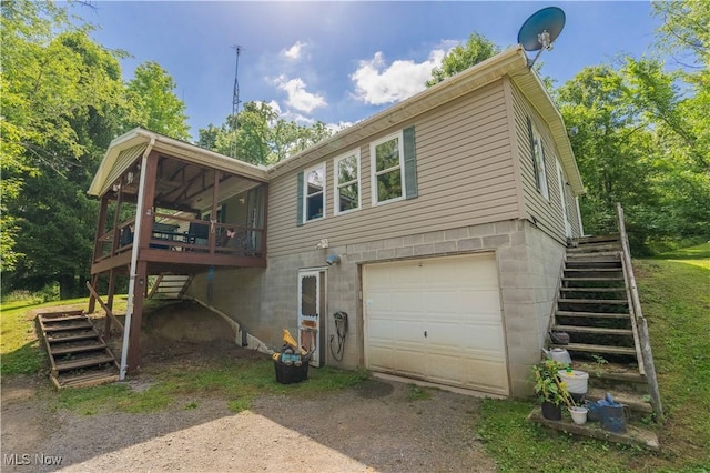 2176 Pageant Rd SE, Carrollton, OH 44615 - view of side of home featuring stairway, an attached garage, dirt driveway, and a wooden deck