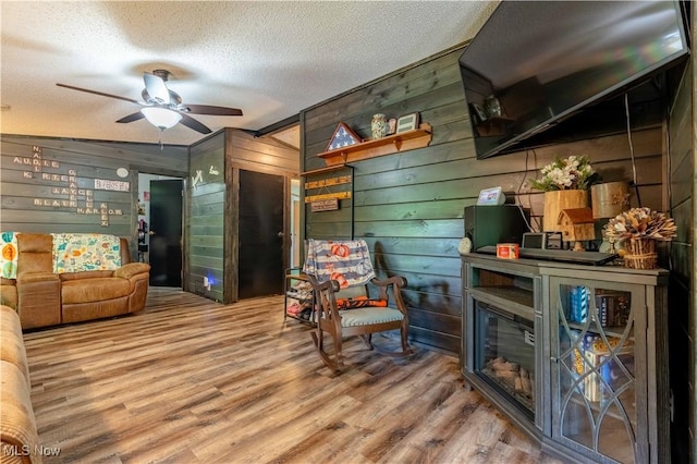 2176 Pageant Rd SE, Carrollton, OH 44615 - living room featuring a textured ceiling, wood finished floors, a ceiling fan, and wooden walls
