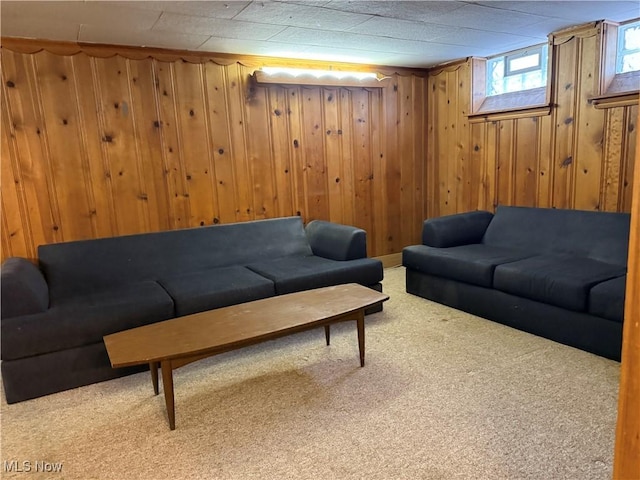 carpeted living area featuring wood walls