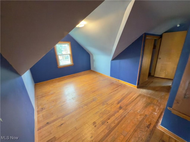 additional living space featuring hardwood / wood-style floors and vaulted ceiling