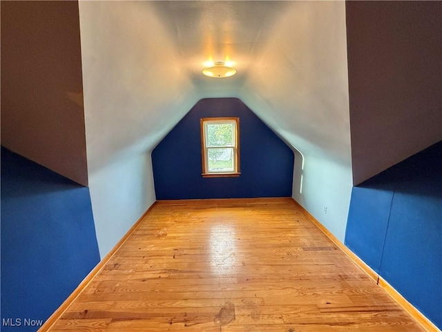 additional living space featuring hardwood / wood-style flooring and vaulted ceiling