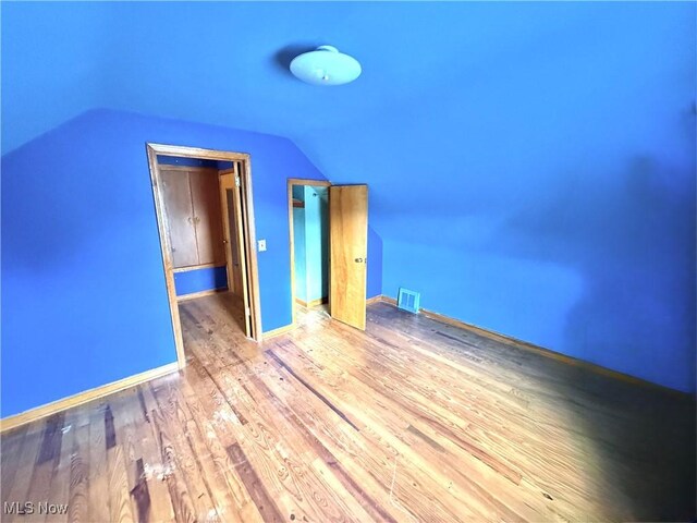 bonus room featuring lofted ceiling and wood finished floors