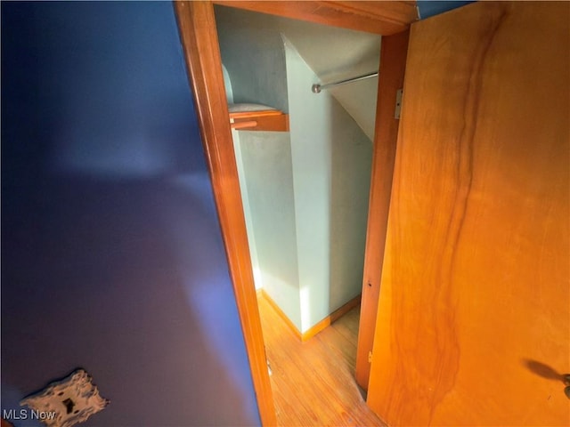 hallway featuring wood finished floors and baseboards