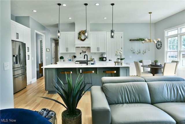 257 Country Club Dr SE, Warren, OH 44484 - kitchen featuring stainless steel refrigerator with ice dispenser, open floor plan, light countertops, light wood-style floors, and recessed lighting