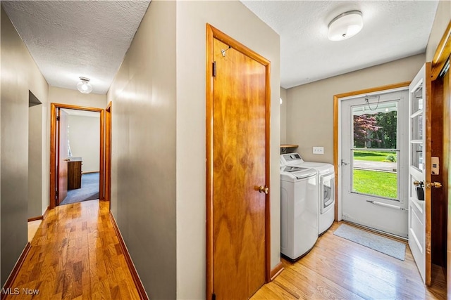 3988 Lake Rd, Conneaut, OH 44030 - laundry room featuring washing machine and clothes dryer, light wood-style flooring, and a textured ceiling