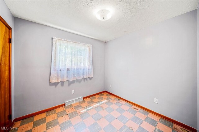 3988 Lake Rd, Conneaut, OH 44030 - unfurnished room with a textured ceiling and tile patterned floors