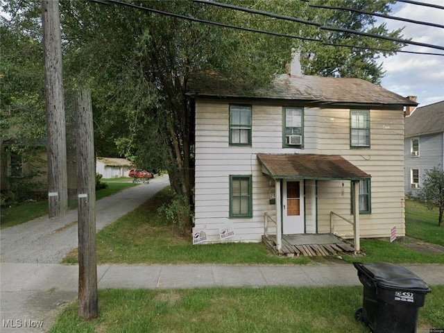 289 S Market St, East Palestine, OH 44413 - view of front of home featuring a chimney, a front yard, and cooling unit