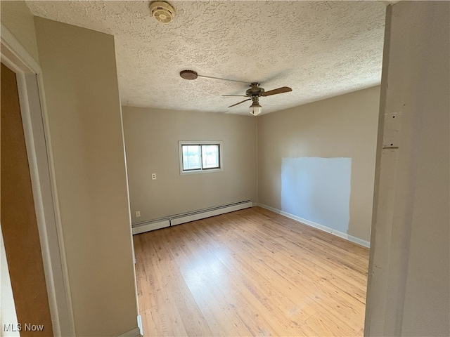 9513 Edison St NE, Alliance, OH 44601 - unfurnished room featuring a baseboard radiator, a smoke detector, ceiling fan, light wood-style floors, and a textured ceiling
