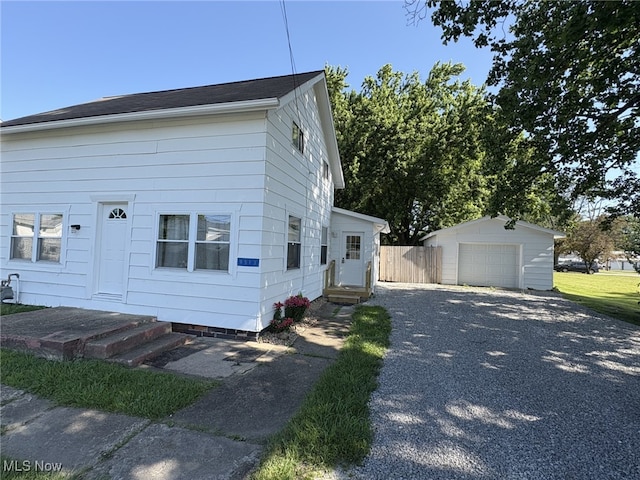 9513 Edison St NE, Alliance, OH 44601 - view of side of property with asphalt driveway, entry steps, an outbuilding, and a detached garage