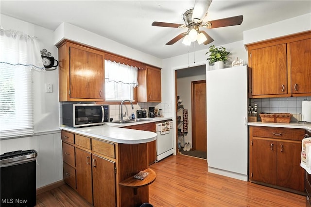 1932 Meister Rd, Lorain, OH 44053 - kitchen featuring stainless steel microwave, white dishwasher, a peninsula, ceiling fan, and light countertops