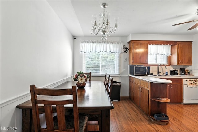 1932 Meister Rd, Lorain, OH 44053 - kitchen featuring white dishwasher, stainless steel microwave, a chandelier, light countertops, and brown cabinets