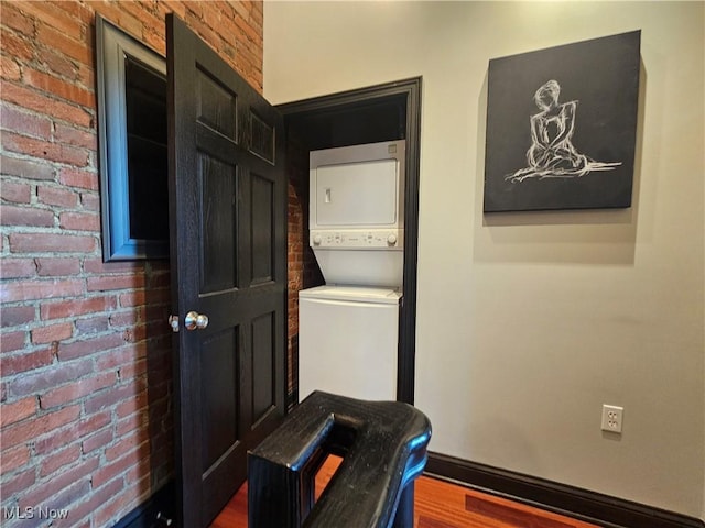 7482 Center St Unit 5, Mentor, OH 44060 - laundry room featuring estacked washer and dryer, brick wall, and wood finished floors